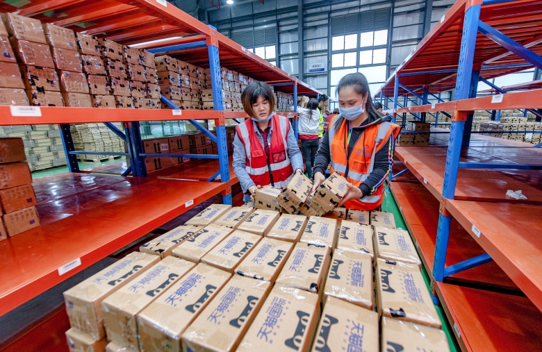 电商活动期间，平潭跨境保税仓持续爆发，工作人员忙着分类商品。
